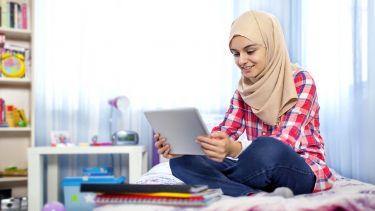 Teenager using a tablet device at home