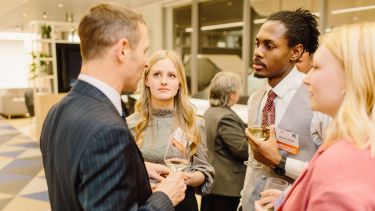 Group of students networking with a Sheffield alumnus