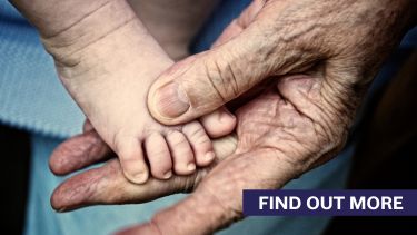 Find out more. Old person holding a baby's foot.