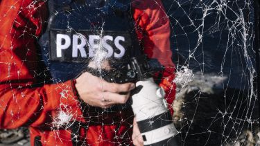 Press journalist reflection in a smashed mirror