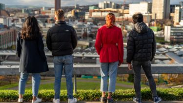 Four students looking at cityscape of Sheffield from Park Hill