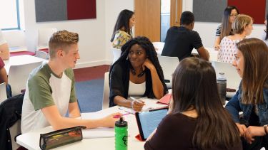 Students in a seminar room sat around tables.