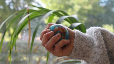 A student holds a stress ball with a globe pattern