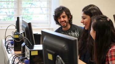 Three students working at a computer