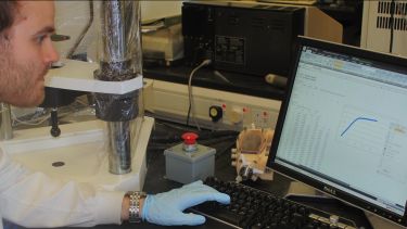 Man working in a lab, on a computer