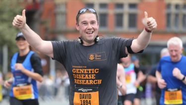 Dave running wearing a t shirt that reads 'fundraising for genetic disease research'