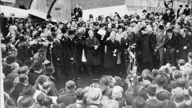 Neville Chamberlain holding the paper containing the resolution to commit to peaceful methods signed by both Hitler and himself on his return from Munich