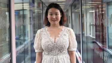 Xiaoyu Guo stood in the Management School's glass corridor.