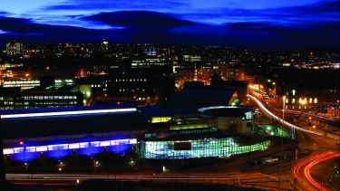 A view over Ponds Forge and the city centre at night.
