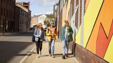 Three students walking through Kelham Island.