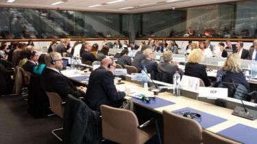A large number of people sat in a European Commission meeting.