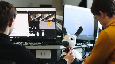 Two students working with a Miro robot