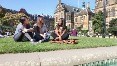 Three students sitting in the Peace Gardens