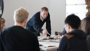 Staff member gesturing to an architectural model