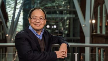 Professor Meihong Wang smiles as he stands in the Engineering Heartspace