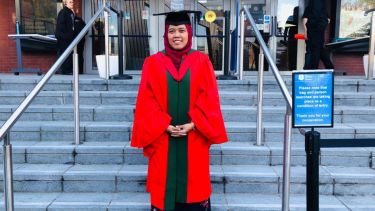 A photo of Yanti in her graduation gown and cap.