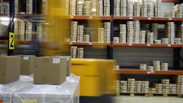 A warehouse with shelves full of cardboard boxes.