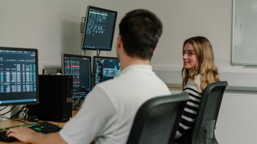 Two students working together in the Trading Room.