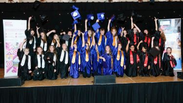A photo showing South Yorkshire Children's University graduates tossing their hats in the air