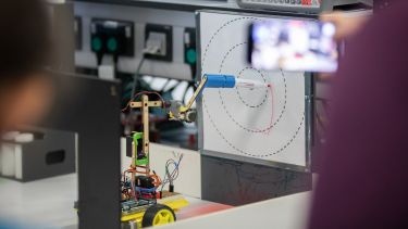 Photo of a robot drawing on a whiteboard