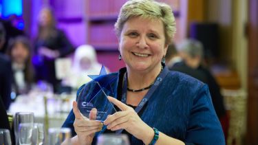 Professor Claire Lewis holding Cancer Research Horizon Award at Dinner