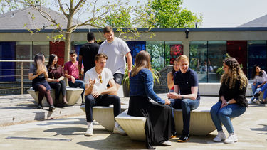 Students socialising in the courtyard on a sunny day.