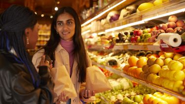 Two students buying fruit and vegetables.