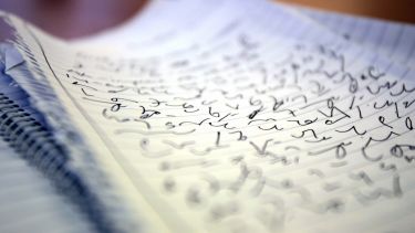 A notebook with lines of teeline shorthand written on it