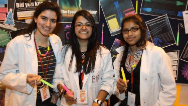 School pupils in lab coats taking part in a science competition