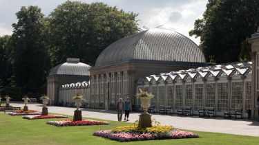 The Victorian greenhouse in the Sheffield Botanical Gardens with flowerbeds in front