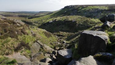 Rocky outcrops and green hills in Padley Gorge near Hathersage