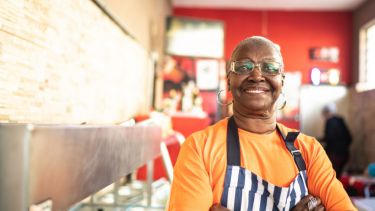 Older woman sat in a cafe at work