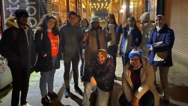 A group of students huddled for a group photograph at the Peddler Market