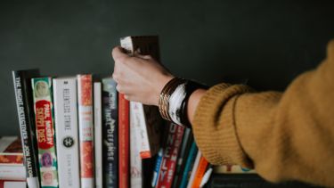 A photo of a hand selecting a book