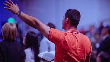 A man worshipping in a gathering.