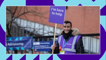 A student ambassador holding a help sign