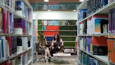 Two students sit reading in the Health Sciences Library