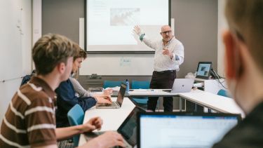 Professor Matthew Flinders presenting slides to a group of students in a seminar