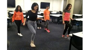 Girls practice dance moves together in a room