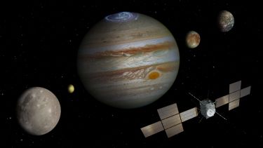 An illustration of Jupiter and its moons being observed by a spacecraft