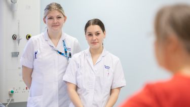 Two student nurses listening to a tutor