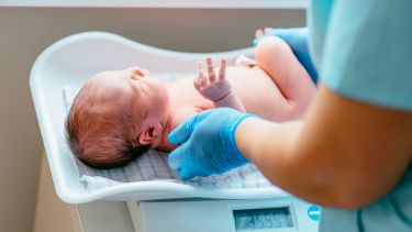 Baby being weighed by a midwife