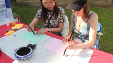 Teacher Junchi instructs at the calligraphy stall