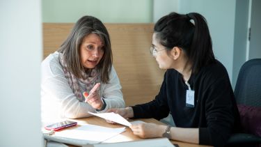 Student and woman in conversation at a table