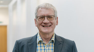 Richard Bruce wearing a checked shirt and a jacket.