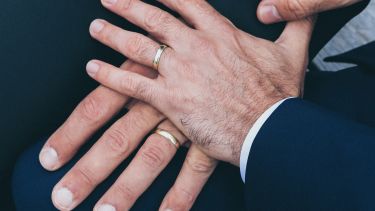Two male hands wearing wedding rings