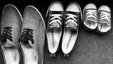 A picture of three sets of shoes - two adult pairs and a toddler pair