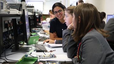 Photograph of Apple Engineer helping pupils with the Arduino microcontroller platform