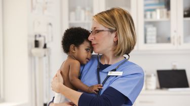 Photo of a doctor holding a young baby