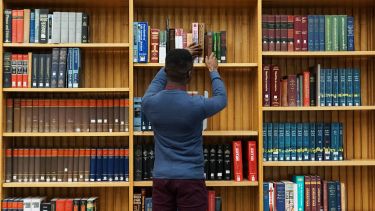 Student choosing a book from the library